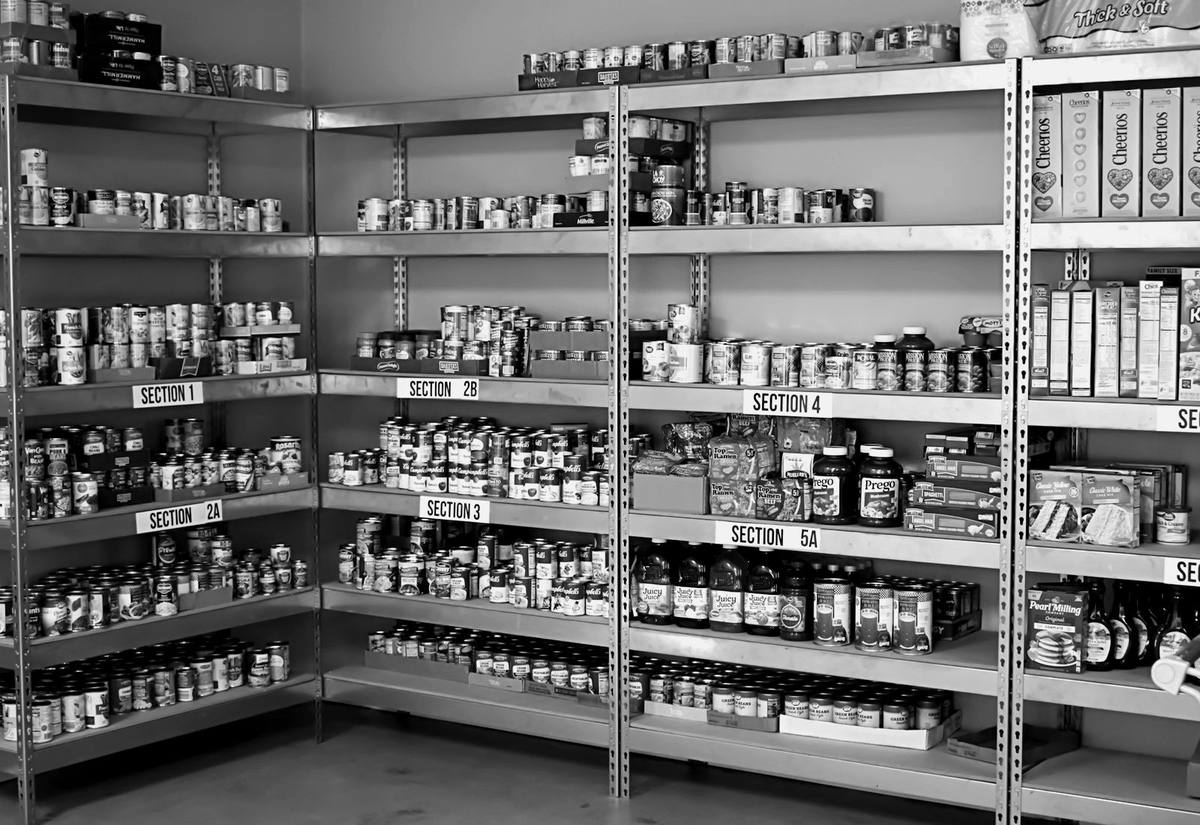 Storeroom shelves full of tins and jars, with section labels