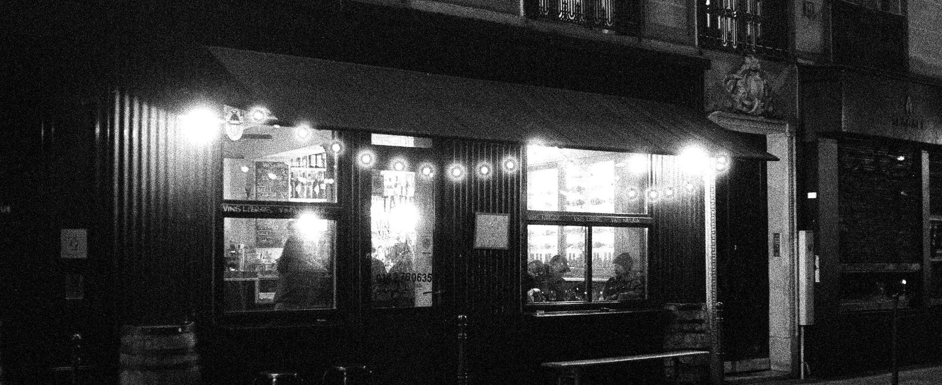 A restaurant front at night, with lights over the windows